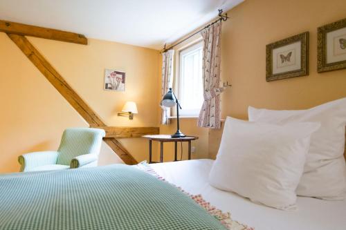 ÜberherrnDer Linslerhof - Hotel, Restaurant, Events & Natur的卧室配有床、椅子和窗户。