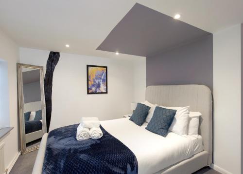 达宁顿堡Donington Cottage Apt 8的卧室配有带蓝色枕头的大型白色床