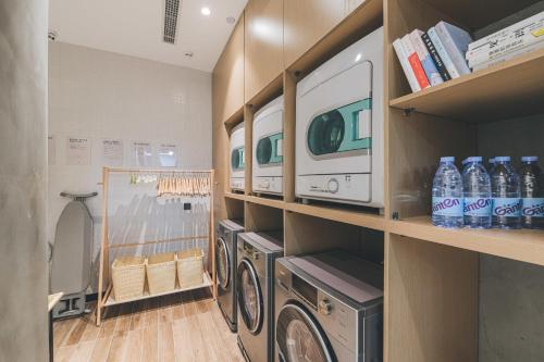 徐州徐州市政府亚朵酒店的洗衣房的架子上设有洗衣机和烘干机