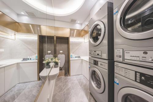南京南京夫子庙中华门地铁站轻居酒店的洗衣房配有洗衣机和烘干机