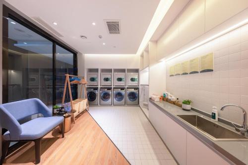大同大同东信广场高铁站亚朵酒店的洗衣房配有水槽和洗衣机