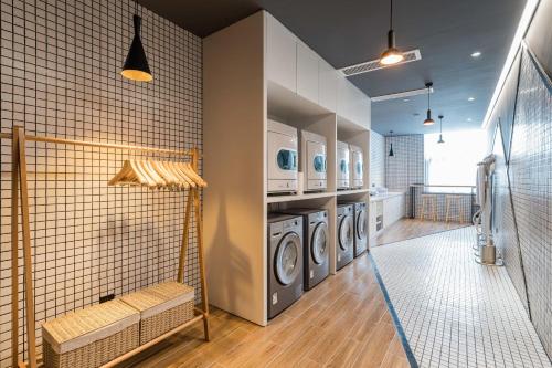 苏州苏州工业园区东沙湖亚朵酒店的洗衣房配有3台洗衣机和烘干机