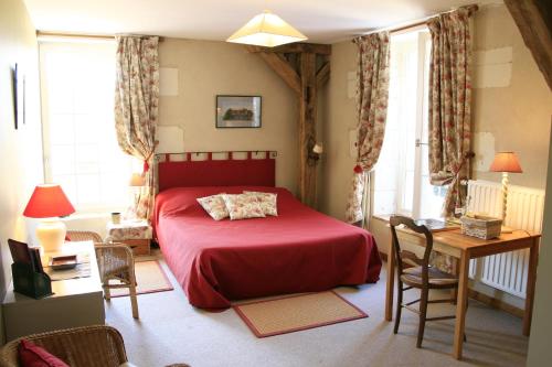 蒙特雷索红磨坊德蒙特莎酒店的一间卧室配有红色的床和桌椅