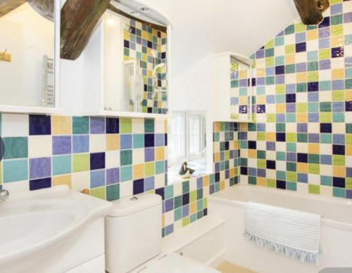 LlanfairBeautiful Cottage in Llanfair with ocean views的浴室配有盥洗盆、卫生间和浴缸。