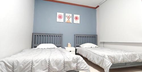 扶余Healinghouse Peakjang的卧室设有两张床铺和蓝色的墙壁