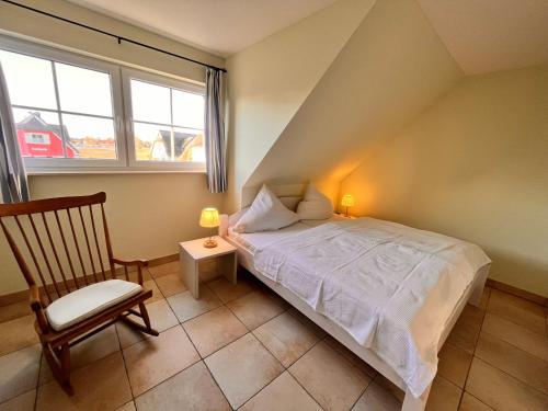 布雷格Ferienhaus Wellenläufer的卧室配有床、椅子和窗户。