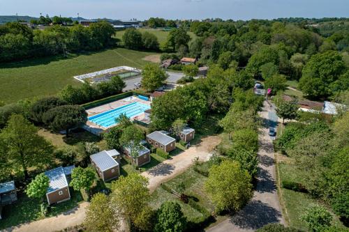 莱瑟佩瑟Camping Capfun La Bretèche的享有带游泳池和树木的度假村的空中景致