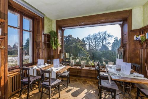 莫尔日伊戈尔宅邸酒店的一间带桌椅和大窗户的用餐室