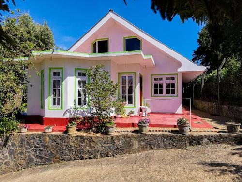 努沃勒埃利耶Nuwara eliya mountain view homestay的前面有盆栽植物的粉红色房子
