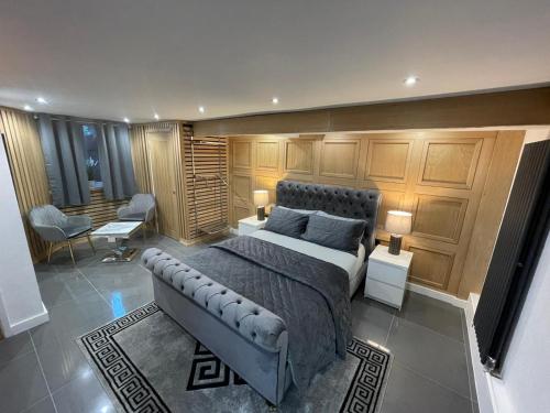 曼彻斯特亨德汉别墅酒店的一间带一张床铺的卧室,位于一个配有木橱柜的房间