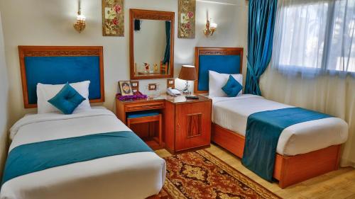 Kafr EL SheikhThe Palm Hotel的酒店客房,设有两张床和镜子