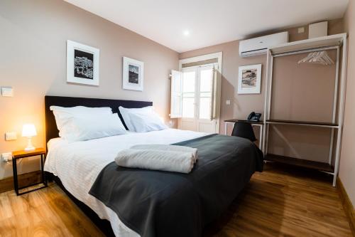 佩奥拉Monreal Boutique Townhouse - R024RM3的一间卧室配有一张带白色床单的大床