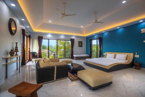 阿利鲍格SaffronStays Aura, Alibaug - luxury pool villa with a game room and spacious lawn的一间卧室配有一张床,客厅配有沙发