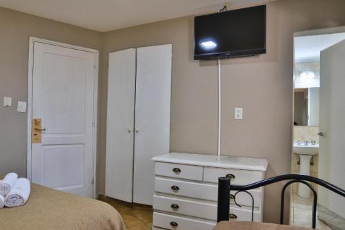 圣卡洛斯-德巴里洛切Trip Bariloche Select的一间卧室配有一张床,墙上设有带电视的梳妆台。
