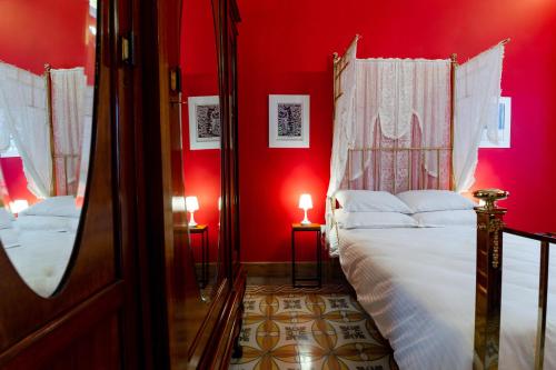 佩奥拉Monreal Boutique Townhouse - R024RM4的卧室设有红色的墙壁和一张带白色床单的床