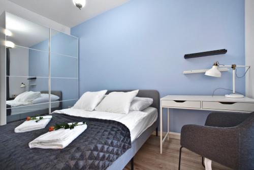 华沙zoliborz的一间卧室配有一张带桌子和椅子的床