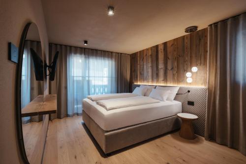 圣维吉利奥Pescosta Chalet Luxury Living的一间卧室配有一张大床和镜子