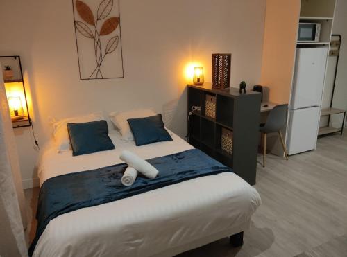 勒阿弗尔Villa Raphaëlle #2 Centre ville avec parking的一间卧室配有一张带蓝色枕头的床和一张书桌