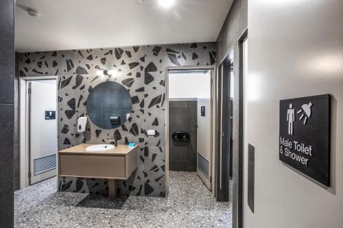 墨尔本Royal Hotel by Nightcap Social的浴室配有水槽和黑白墙