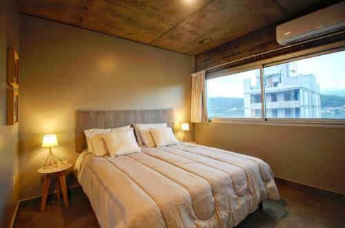 圣萨尔瓦多德朱Naranjo 9A的一间卧室设有一张大床和大窗户