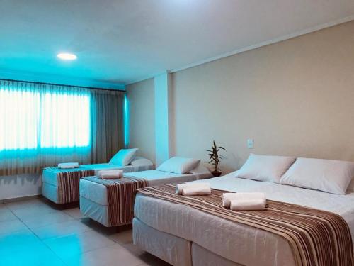 伊瓜苏Hotel Castelo Branco的酒店客房,配有两张床和椅子