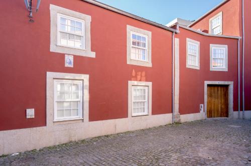 波尔图Habitatio - Foz的红色的建筑,有白色的窗户和门