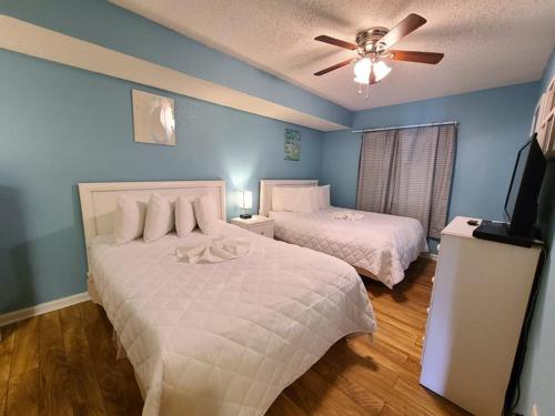 默特尔比奇Atlantica Resort III的一间卧室配有两张床和吊扇