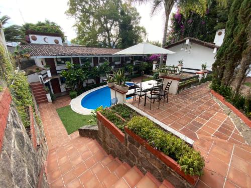 巴耶德布拉沃Casa Dalinda的房屋设有带桌子和遮阳伞的庭院