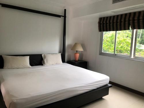卡图兰花卡图高地服务式公寓的一间卧室设有一张大床和两个窗户。