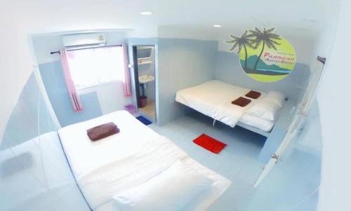 哈林海滩Phangan Mantra Inn的小房间设有两张床和窗户