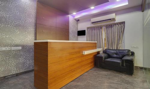 钦奈Treebo Rithikha Inn Elite Chennai Trade Centre的一间设有真皮座椅和书桌的等候室