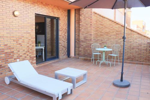 马德里佳利昂G3公寓酒店的庭院配有遮阳伞和桌椅。