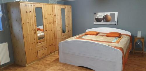 伦山前比绍夫斯海姆Ferienwohnung Gutwin的一间卧室配有一张床和一个木制橱柜