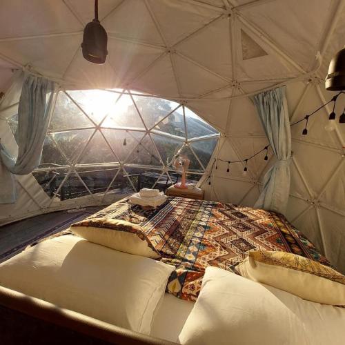 Ban Maiเตนท์โดมชายดอย ดอยแม่แจ๋ม ลำปาง的帐篷内的一个床位房间