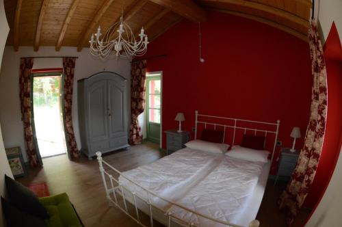 多马索Tuschaus的卧室配有红色墙壁内的一张床