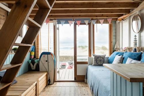 基督城Stargazing Beach Hut on Mudeford Sandbank with wake up sea views的一间卧室设有一张床和一个大窗户