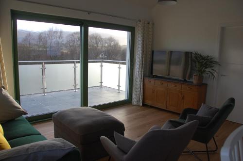 史宾桥Glas Beag的客厅设有大窗户和电视。