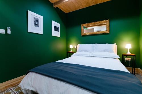 佩奥拉Monreal Boutique Townhouse - R024RM5的绿色卧室,配有床和绿色的墙壁