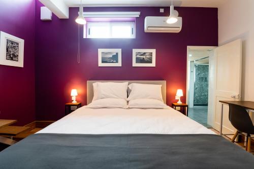 佩奥拉Monreal Boutique Townhouse - R024RM6的一间卧室设有一张紫色墙壁的大床