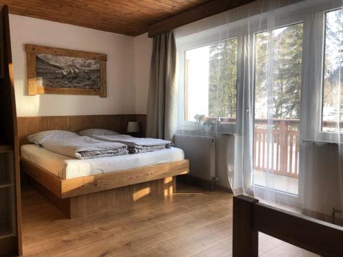 斯卡尔尼茨Karwendel-Lodge的一间卧室设有一张床和一个大窗户