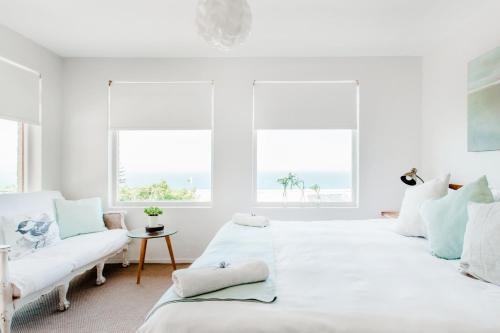 卡尔克湾The Ley @ The Sea的一间白色卧室,配有两张床和两个窗户