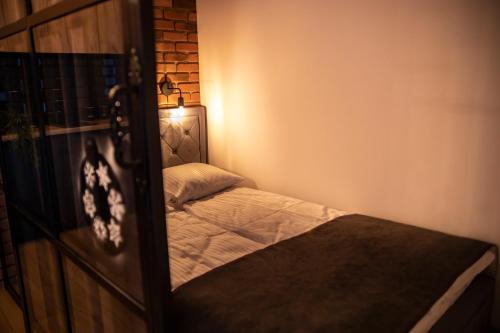 波罗宁Warsztat Apartamenty Stare Izby的一间小卧室,配有床和灯