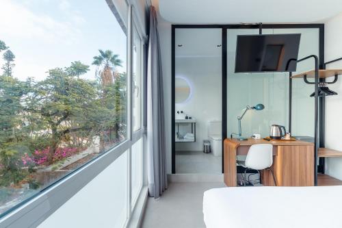 大加那利岛拉斯帕尔马斯Flatguest RoomTiques Private Rooms的卧室设有大窗户和书桌