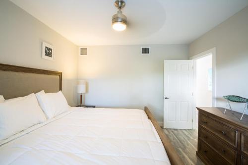普罗维登西亚莱斯岛The Tides, Grace Bay的一间卧室配有一张白色大床和木制梳妆台