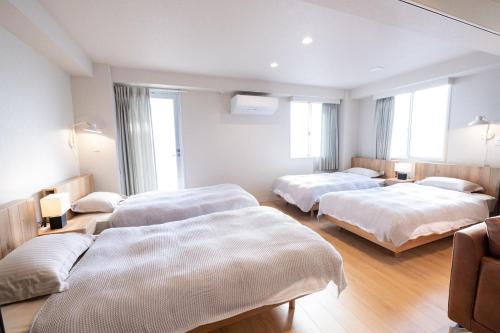 高知RESIDENCE HARIMAYA-Vacation STAY 99860v的酒店客房带三张床和窗户