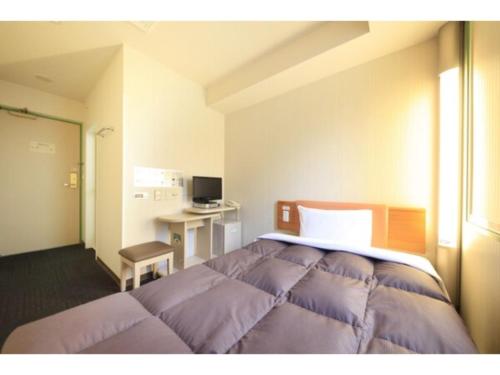 仙台R&B Hotel Sendai Hirosedori Ekimae - Vacation STAY 39659v的一间卧室配有一张床和一张书桌