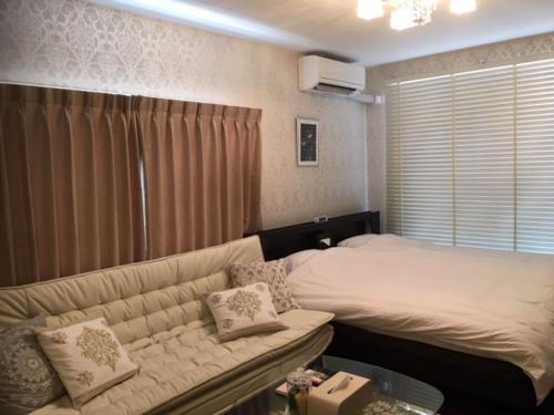 高松Alphabed Takamatsu Furujinmachi - Vacation STAY 11906的客厅配有沙发和1张床