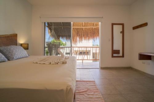 图卢姆Hotel Sonno Caliza Tulum的一间卧室设有一张床,享有阳台的景色