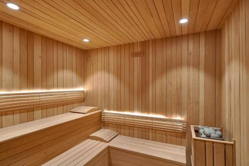 圣多明各Monaco Residences Piantini的一间设有木镶板和2张长椅的桑拿浴室
