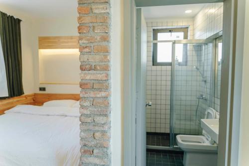 安塔利亚FLANEUR HOSTEL的卧室设有砖墙,毗邻一张床